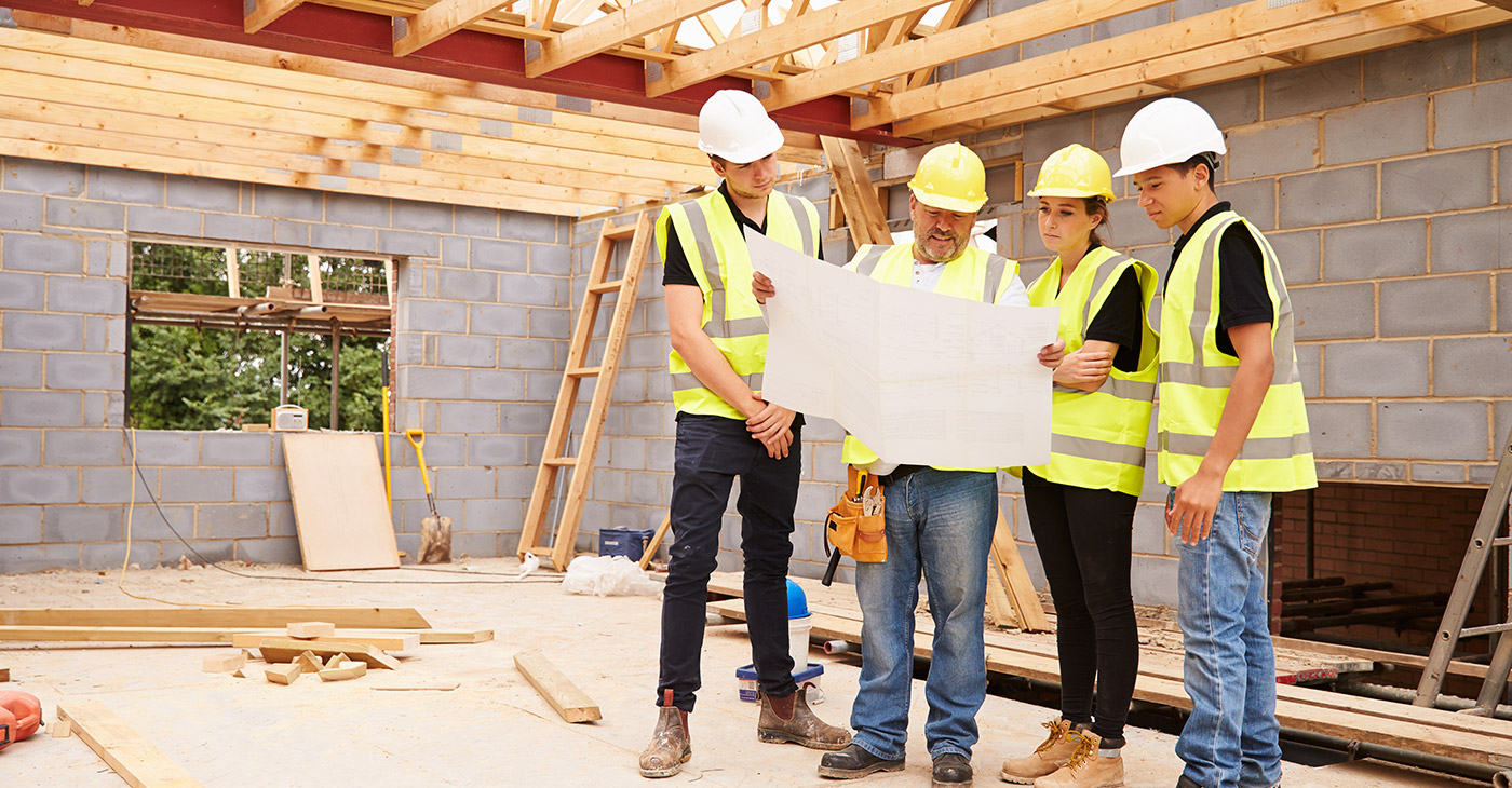 Owner-builders review architectural plans on site for their new home