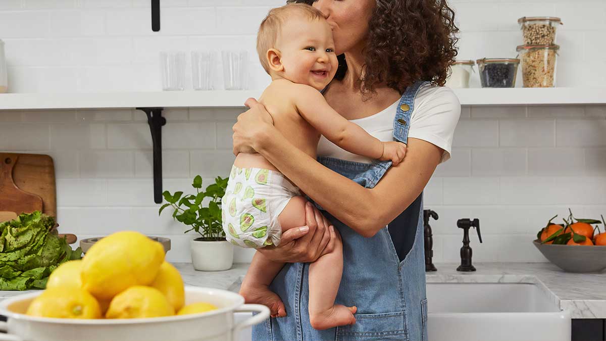 mother with baby in arms in kitchen